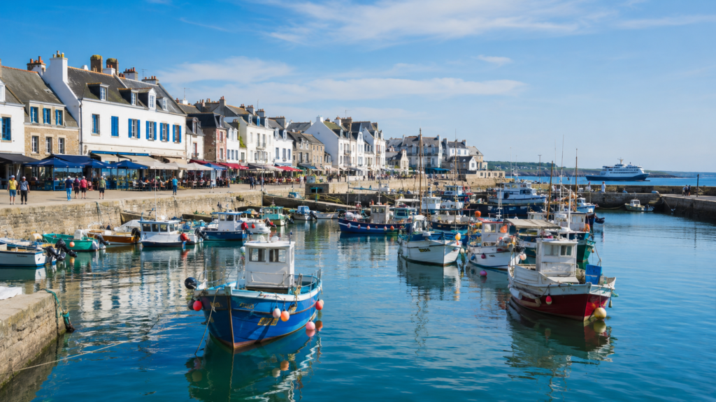 Port Maria à Quiberon avec bateaux de pêche, quais ensoleillés et maisons bretonnes.