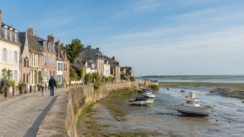 Quais de Saint-Valery-sur-Somme avec maisons anciennes, petits bateaux et baie à marée basse.
